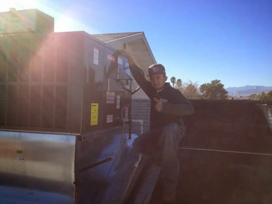 HVAC technician performing HVAC Inspection on a rooftop unit in Clark